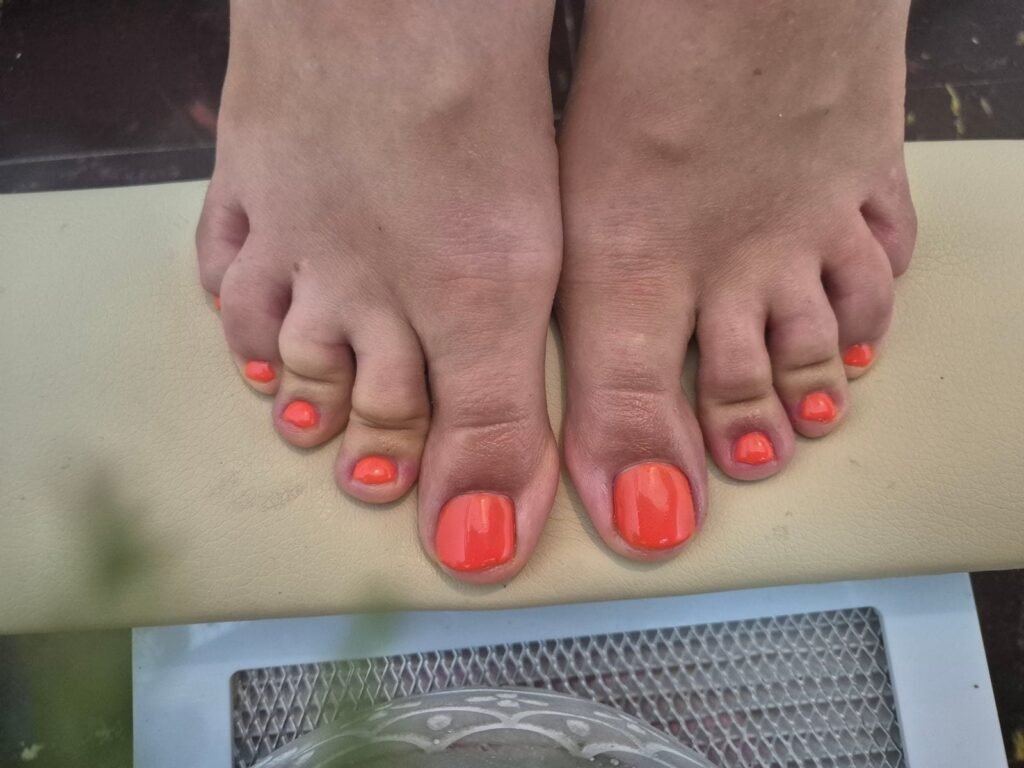 Ongles des pieds avec finition rouge corail brillante