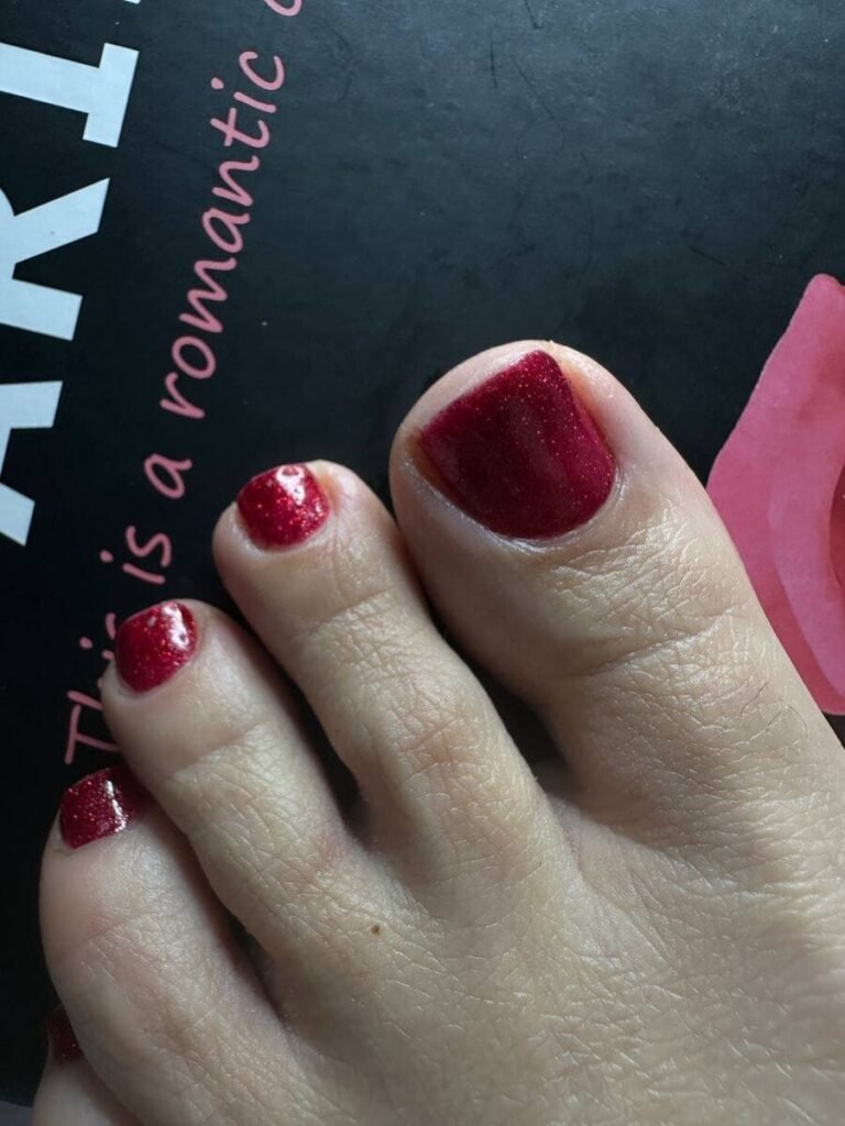 Vue rapprochée des ongles des pieds bordeaux scintillants