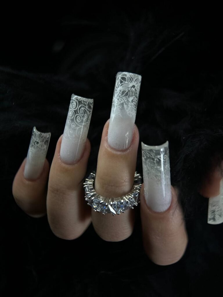 Ongles longs carrés translucides ornés de fins motifs blancs