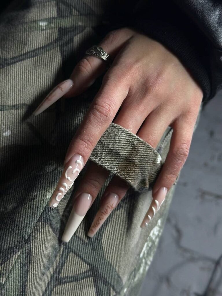 Ongles longs carrés nude avec pointes et motifs blancs