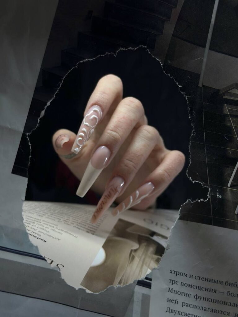 Ongles longs nude avec lignes blanches courbes