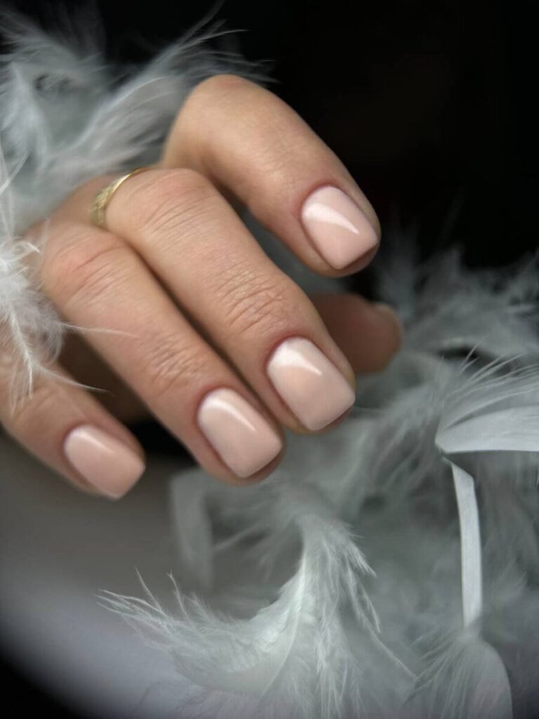 Ongles courts carrés aux angles arrondis avec finition rose nude brillante