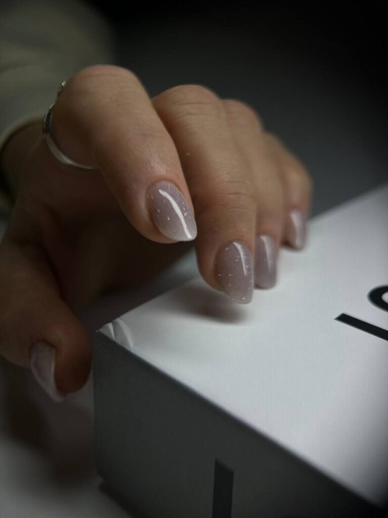 Ongles courts nude avec reflets scintillants discrets