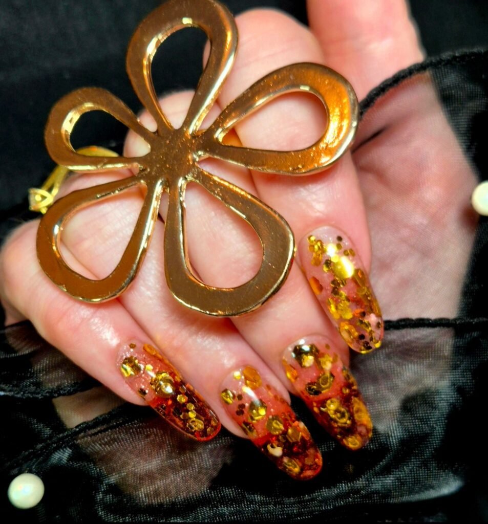 Ongles longs transparents aux tons ambrés avec éclats dorés