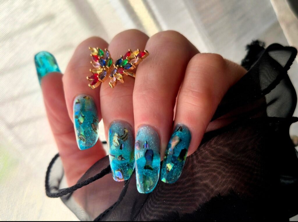 Ongles longs avec nail art turquoise et détails dorés